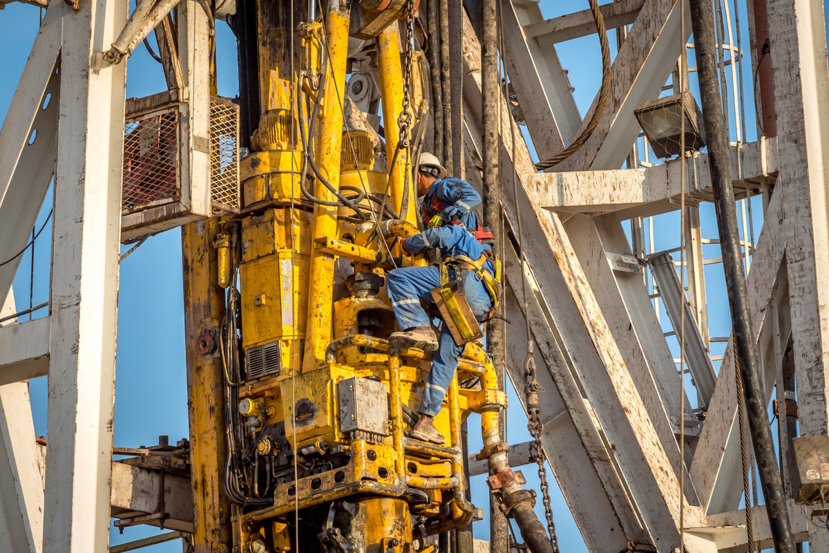 Offshore mechanics working on a top drive assembly during drilling operations
